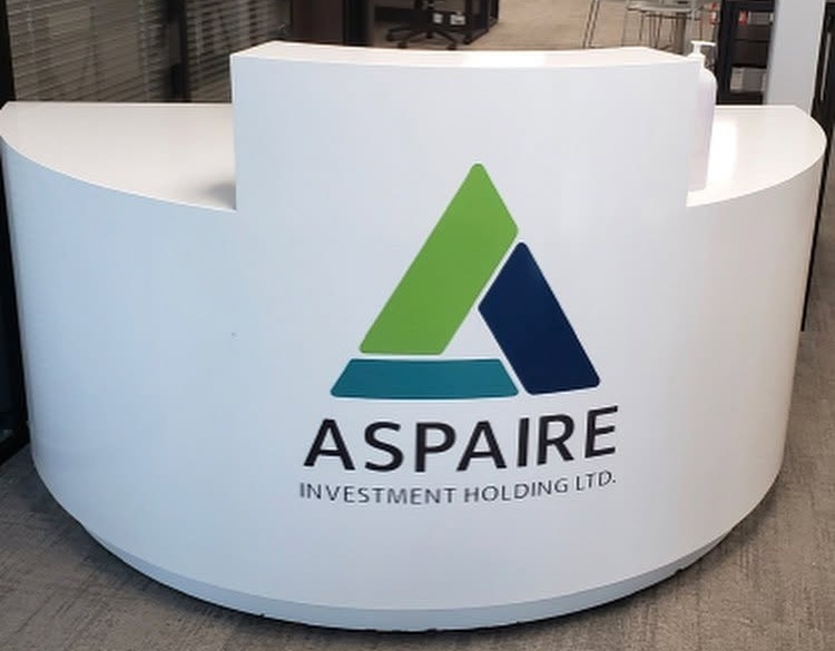 Aspaire logo applied to a curved white reception desk